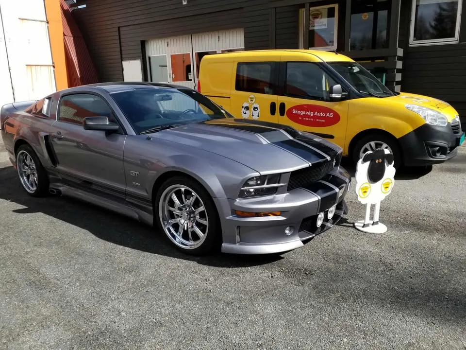 Grå Ford Mustang foran firmabilen til Skogsvåg Auto